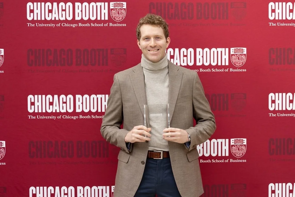 Alexander Hamilton 在芝加哥布斯商学院背景前微笑