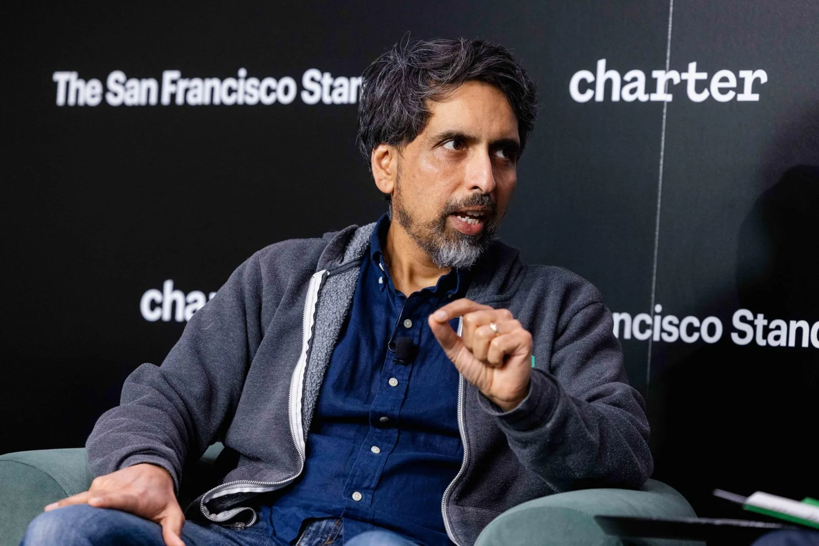 Sal Khan speaking at a panel with The San Francisco Standard and Charter logos in the background